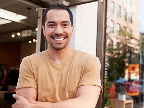 A personal support worker smiling and standing outside